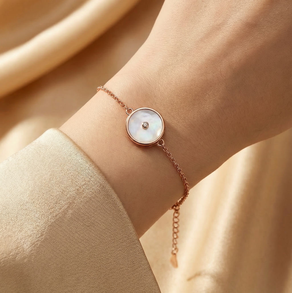 Rose gold bracelet with a round dial on a wrist against a beige background