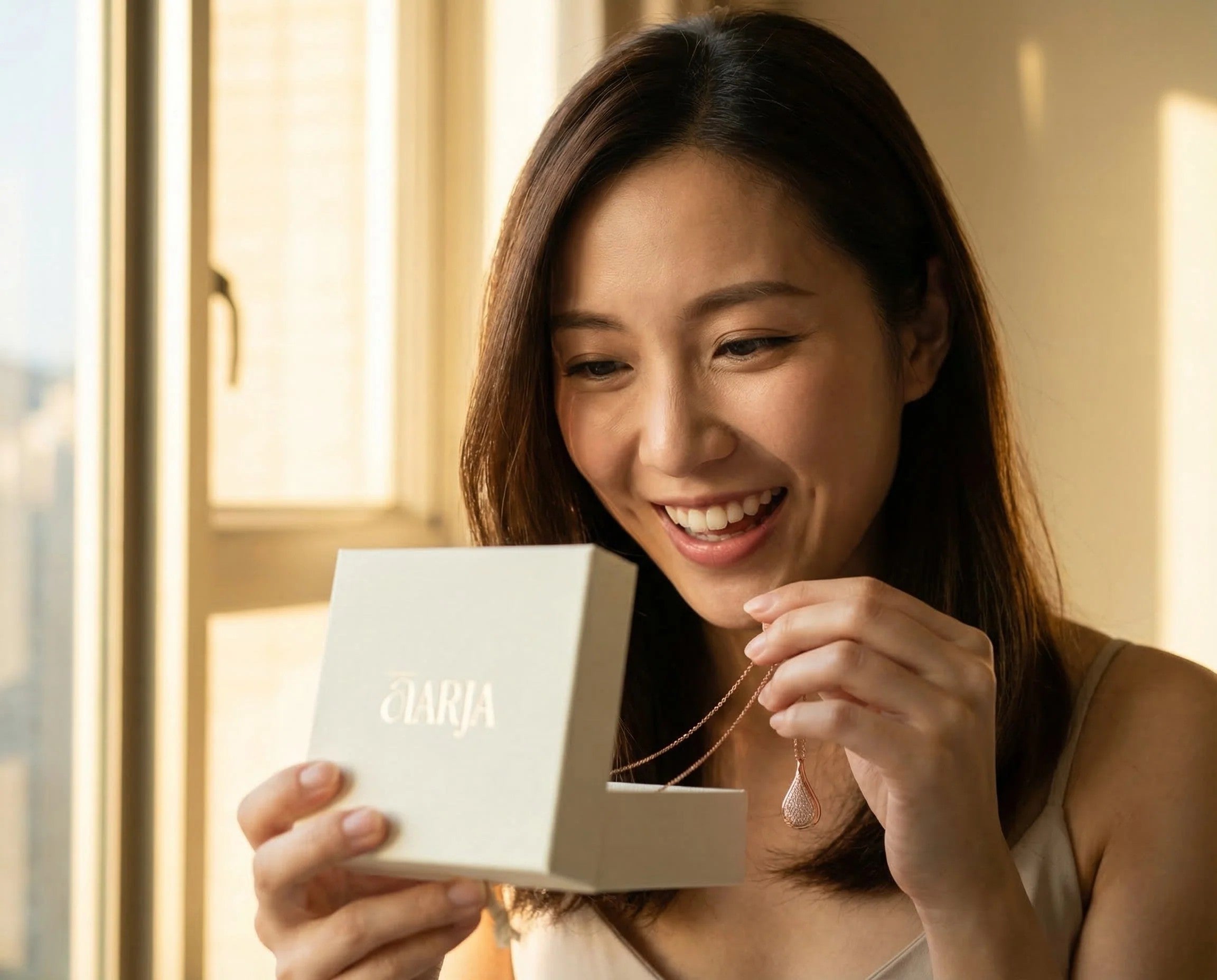 Woman opening an ĀARJA aromatherapy jewelry gift